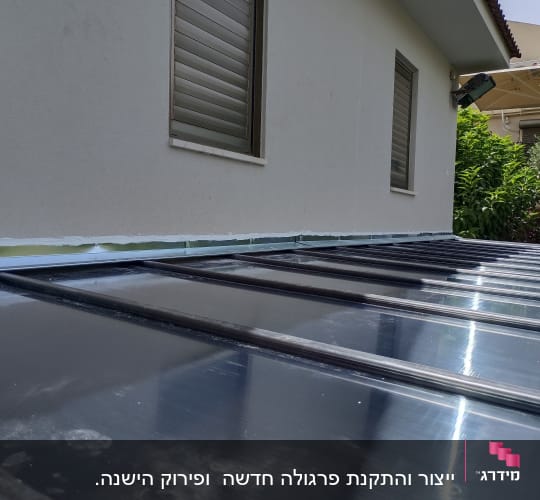 פרגולה מאלומיניום עם לוחות שקופים צמודה לקיר